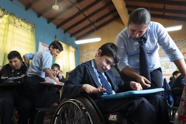 Niño con tableta y docente acompañando